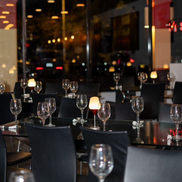 Elegant dining room at Costanera Peruvian Cuisine with set tables, wine glasses, and soft lighting.